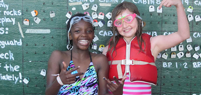 Two girls from Camp Oz in swimming gear goofing for the camera.